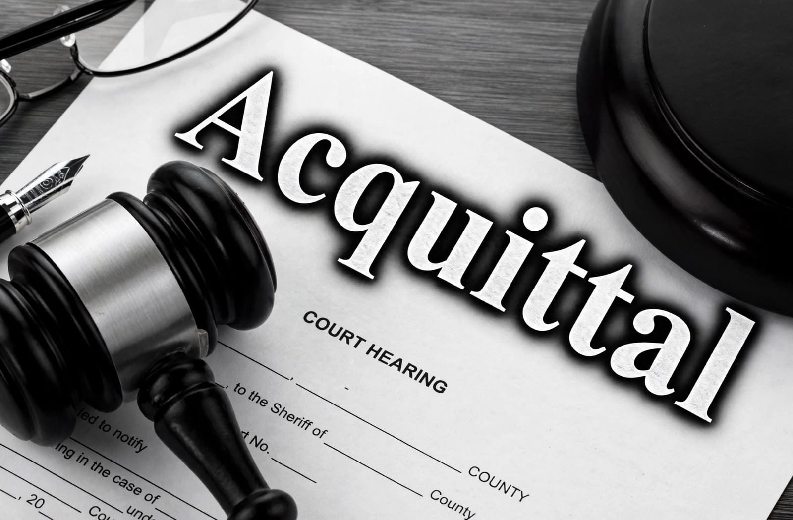 Gavel on a court hearing document marked Acquittal